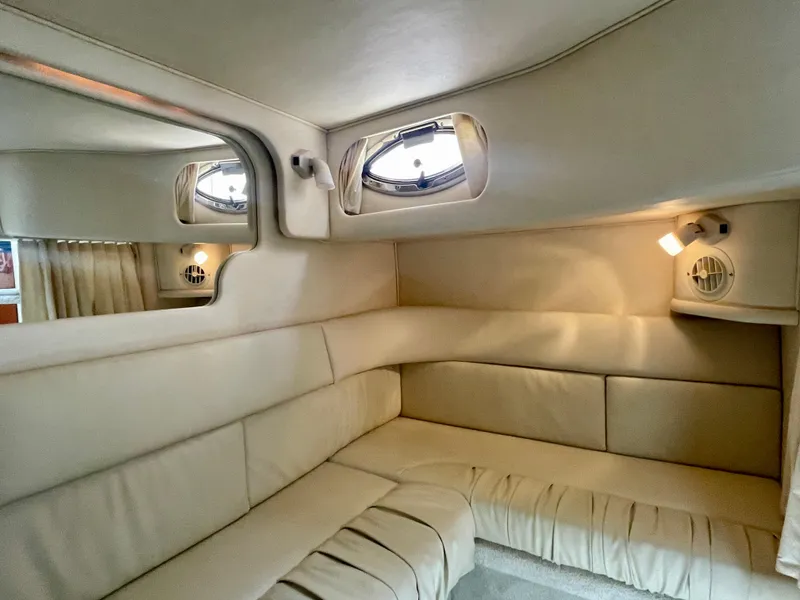 Slide: The Image of Interior of 2001 Sea Ray 340 Sundancer with beige seating and porthole windows. - 25