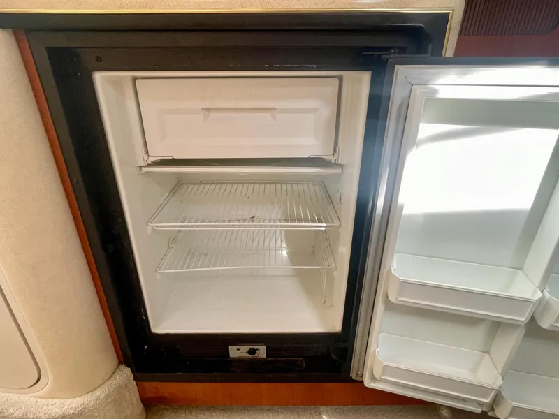 Slide: The Image of Open refrigerator inside a 2001 Sea Ray 340 Sundancer yacht, showing empty shelves. - 27