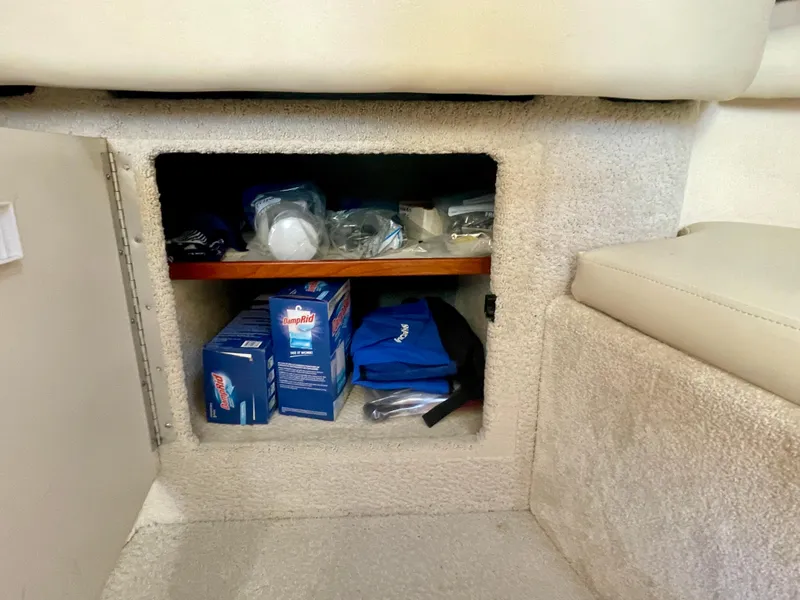 Slide: The Image of Storage compartment in a 2001 Sea Ray 340 Sundancer boat, containing various supplies. - 28