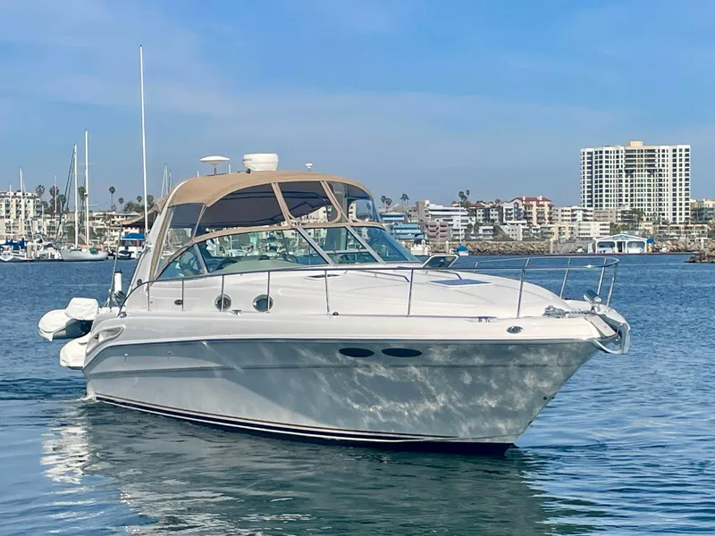 Slide: The Image of 2001 Sea Ray 340 Sundancer yacht on calm water with cityscape background. - 3