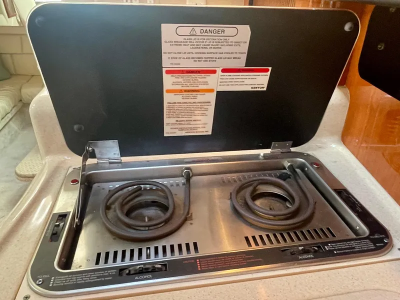 Slide: The Image of 2001 Sea Ray 340 Sundancer stove with dual burners and safety instructions. - 31