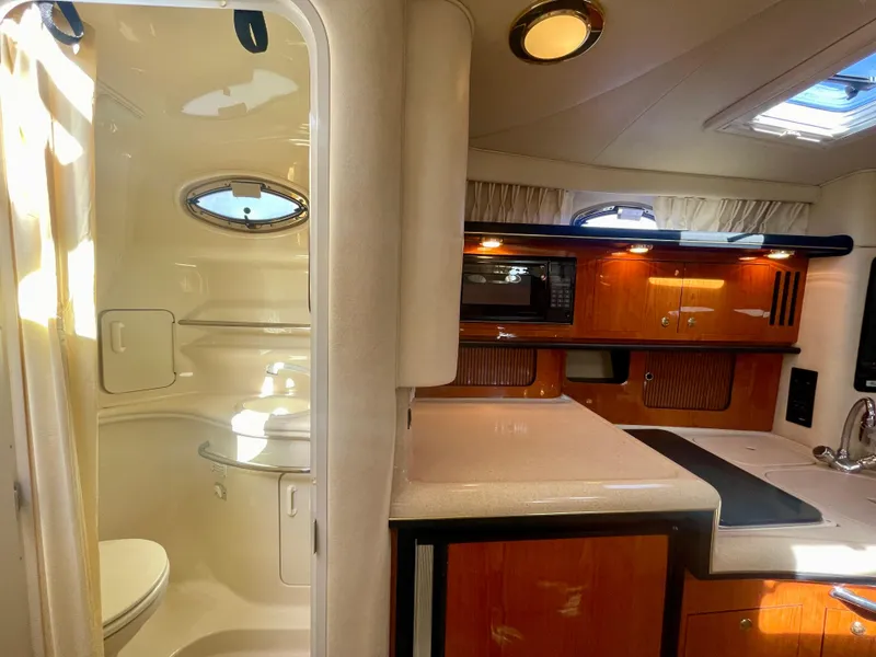 Slide: The Image of Interior of 2001 Sea Ray 340 Sundancer yacht, featuring kitchenette and bathroom. - 37