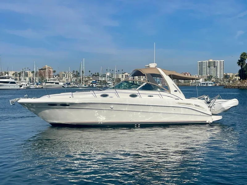 Slide: The Image of 2001 Sea Ray 340 Sundancer yacht on calm water, marina background. - 4