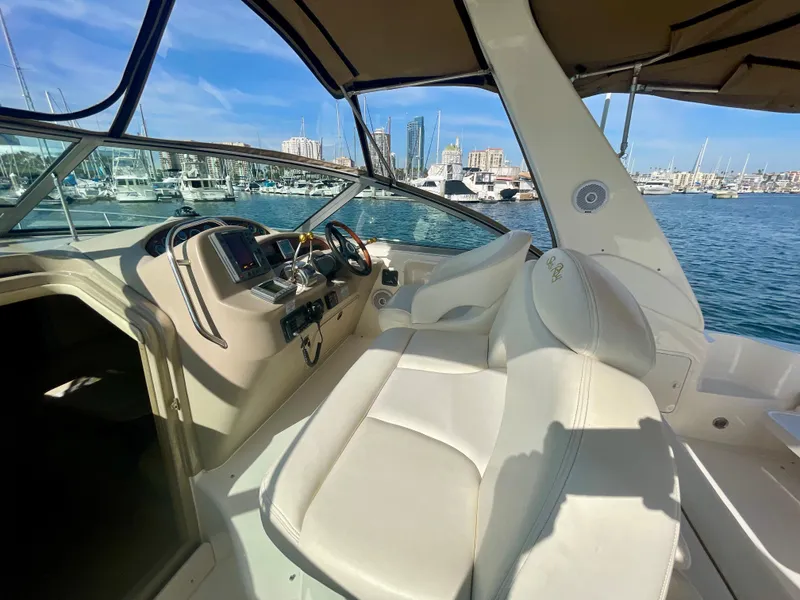 Slide: The Image of 2001 Sea Ray 340 Sundancer cockpit with helm, marina view, and clear blue sky. - 9