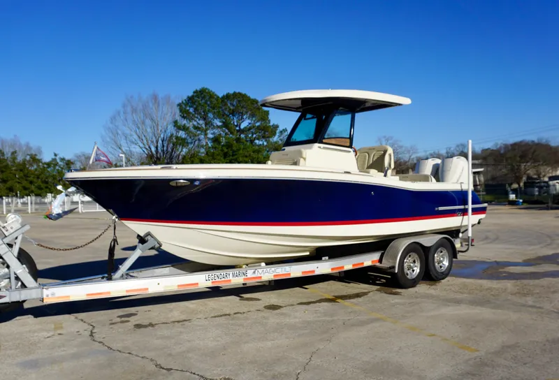 Slide: The Image of 2021 Chris-Craft Catalina 27 boat on trailer, blue hull, parked outdoors. - 2