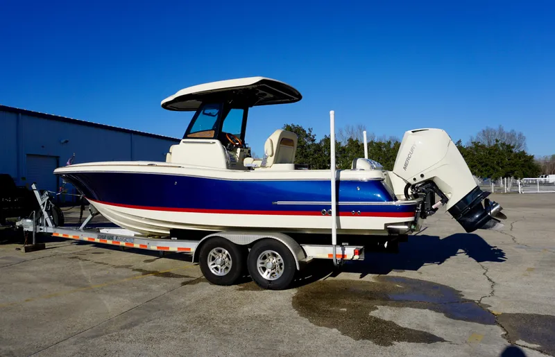 Slide: The Image of 2021 Chris-Craft Catalina 27 boat on trailer, blue and white design, parked outdoors. - 3