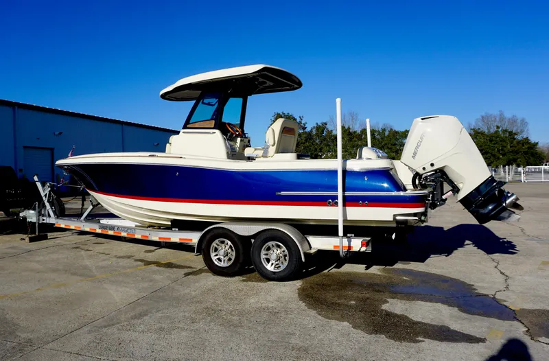 Slide: The Image of 2021 Chris-Craft Catalina 27 boat on trailer, blue and white design, parked outdoors. - 4