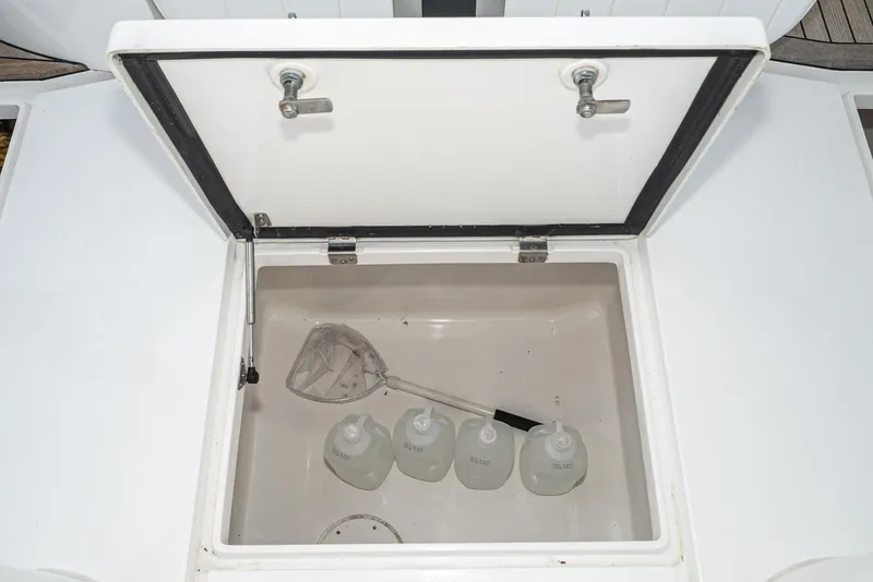 Slide: The Image of Open storage compartment on 2010 Intrepid 43 Sport Yacht with bottles and a net. - 16