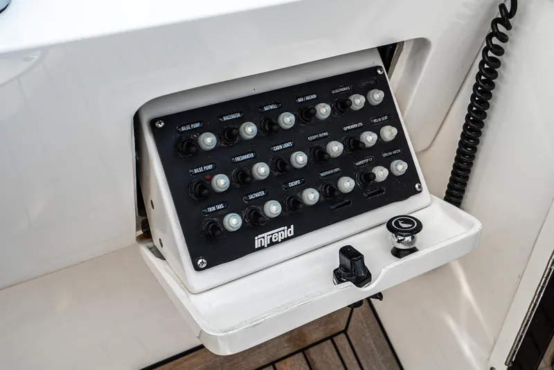 Slide: The Image of Control panel of a 2010 Intrepid 43 Sport Yacht with labeled switches and buttons. - 22