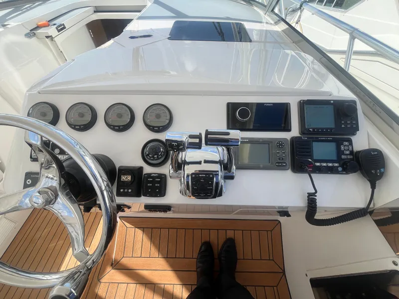 Slide: The Image of Control panel of a 2010 Intrepid 43 Sport Yacht with navigation instruments and steering wheel. - 23