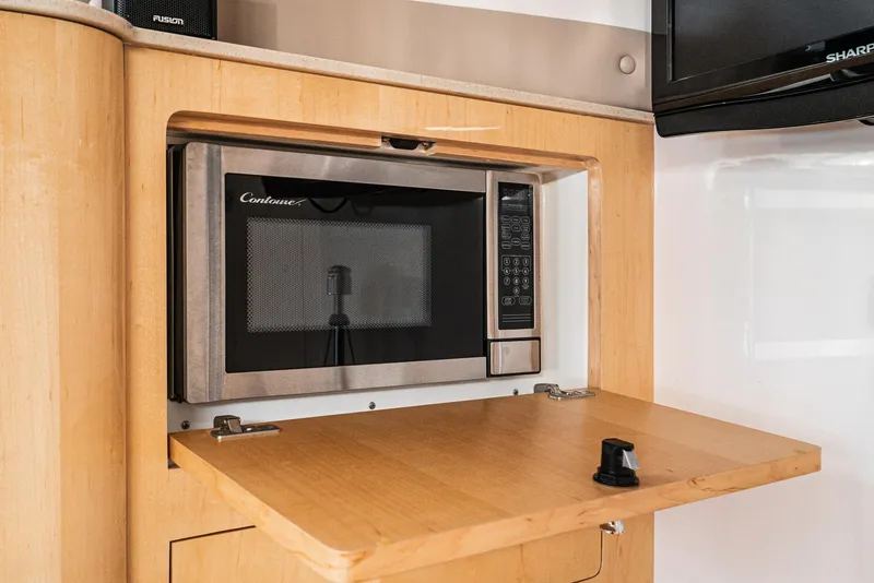 Slide: The Image of Built-in microwave in 2010 Intrepid 43 Sport Yacht's wooden interior kitchen area. - 31