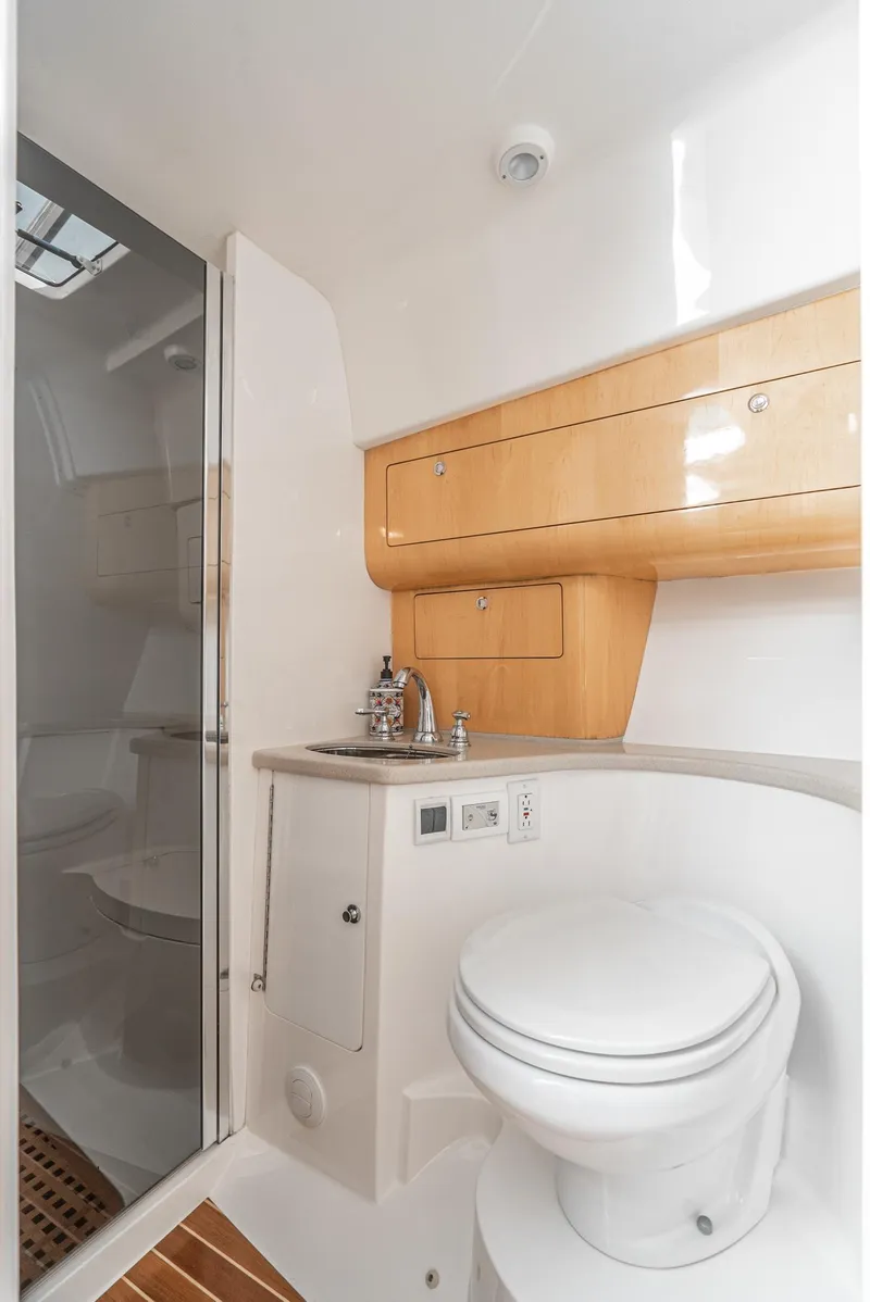 Slide: The Image of 2010 Intrepid 43 Sport Yacht bathroom with shower, sink, and wooden cabinetry. - 34