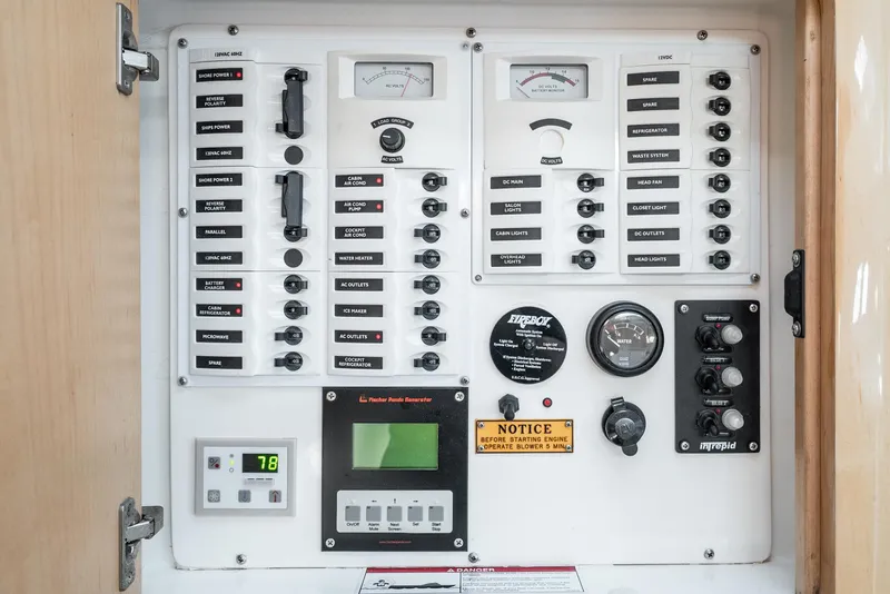 Slide: The Image of Control panel of a 2010 Intrepid 43 Sport Yacht with various switches and gauges. - 38