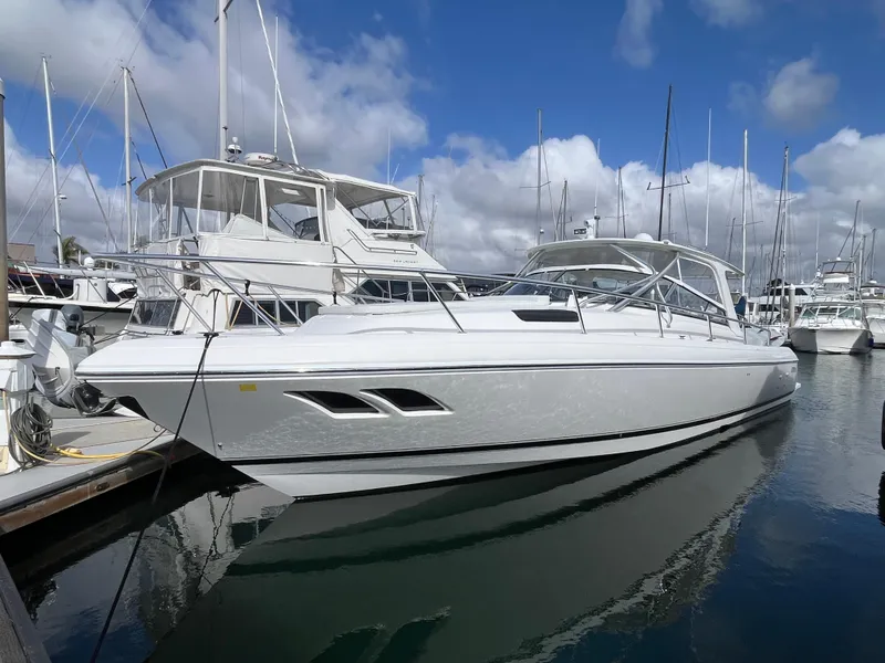 Slide: The Image of 2010 Intrepid 43 Sport Yacht docked in a marina under a cloudy sky. - 43