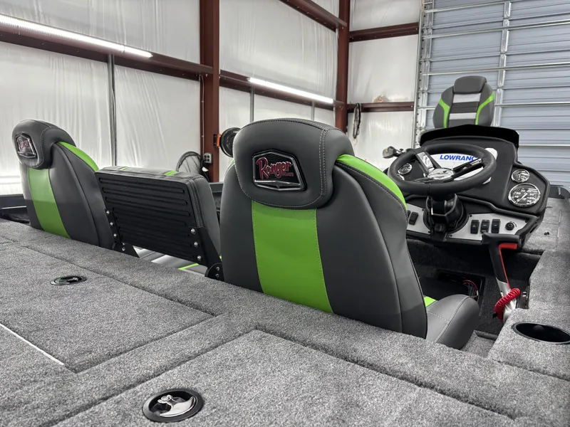 Slide: The Image of 2025 Ranger RT198P boat interior with green and black seats, steering console, and carpeted flooring. - 10