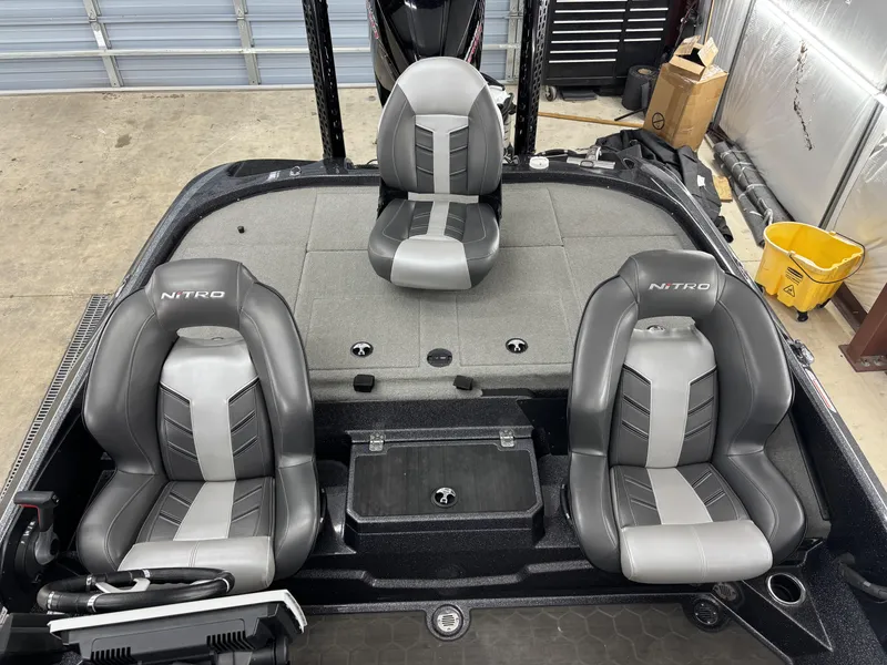 Slide: The Image of 2023 Nitro Z20 Pro boat interior with three gray seats in a garage setting. - 10