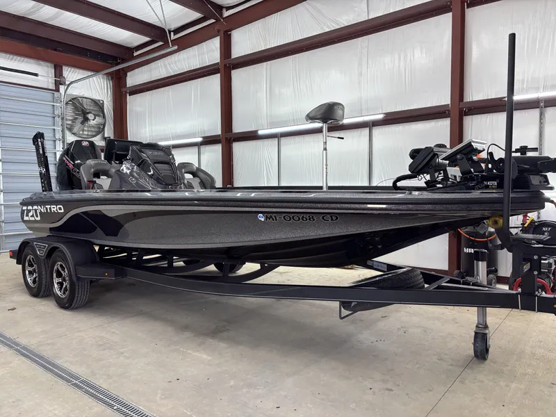 Slide: The Image of 2023 Nitro Z20 Pro bass boat in a garage, sleek design, dual-axle trailer. - 11