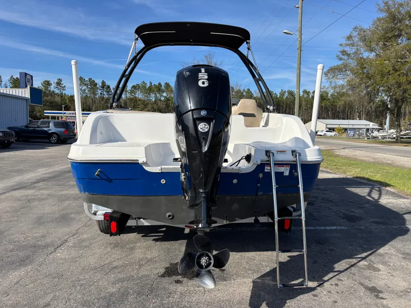 Slide: The Image of 2021 Hurricane SS 201 boat with outboard motor and ladder, parked outdoors. - 30