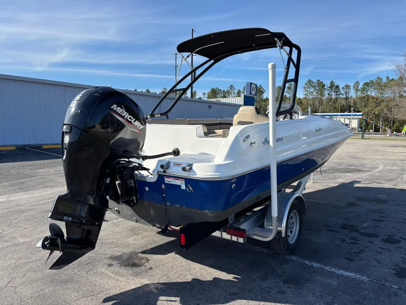 Slide: The Image of 2021 Hurricane SS 201 boat with Mercury outboard motor on trailer, parked outdoors. - 5