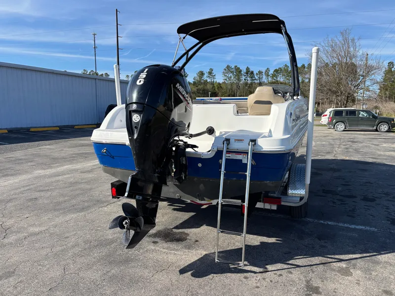 Slide: The Image of 2021 Hurricane SS 201 boat with outboard motor and ladder, parked outdoors. - 8