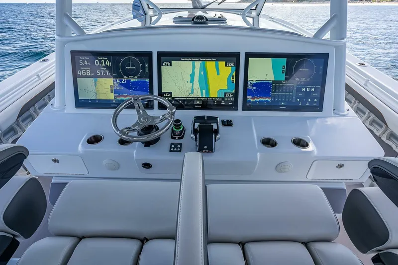 Slide: The Image of 2024 Yellowfin 54 Offshore boat dashboard with advanced navigation screens and controls. - 23