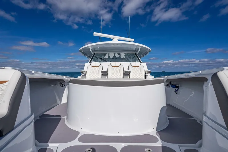 Slide: The Image of 2024 Yellowfin 54 Offshore boat with sleek design on open water under blue sky. - 27