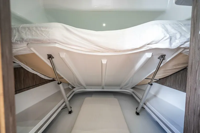 Slide: The Image of 2024 Yellowfin 54 Offshore cabin interior with raised bed and storage space. - 31