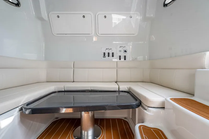 Slide: The Image of 2024 Yellowfin 54 Offshore interior with white seating and a sleek table. - 34