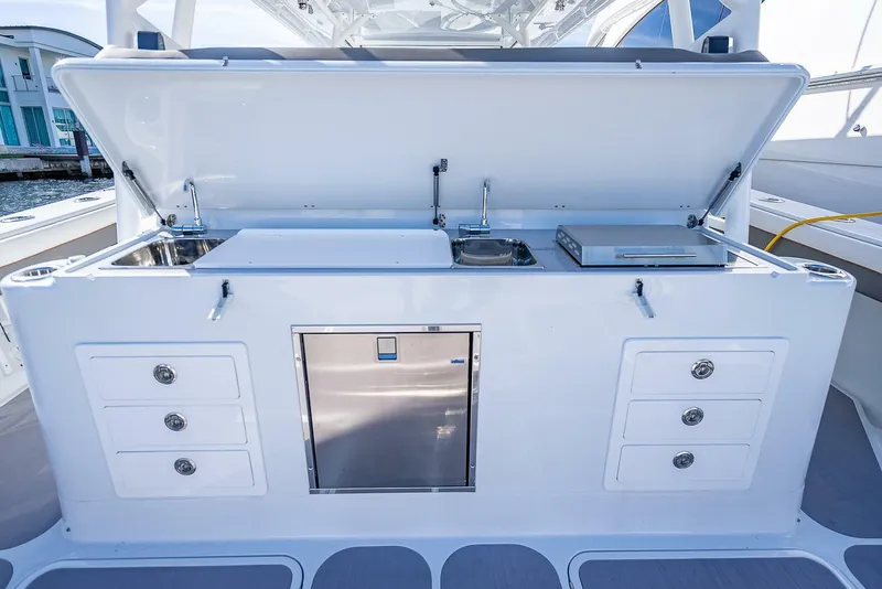 Slide: The Image of 2024 Yellowfin 54 Offshore boat kitchen with storage drawers and stainless steel appliances. - 35