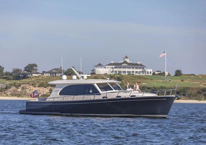 Slide: The Image of Luxury Eastbay EB60 yacht cruising near a coastal mansion, 2026 model. - 0