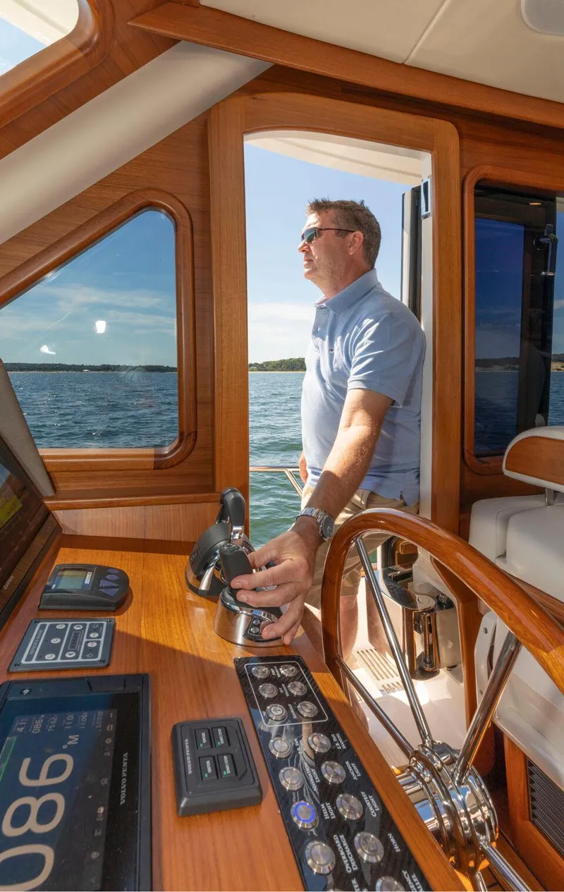 Slide: The Image of Man steering 2026 Eastbay EB60 yacht, enjoying sunny day on the water. - 24