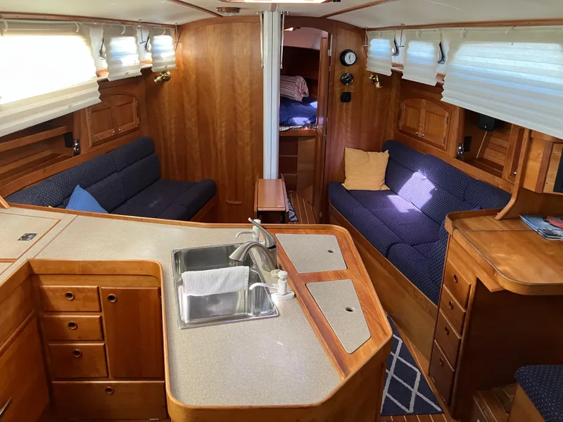 Slide: The Image of Interior of a 1997 Sabre 402 sailboat with wooden cabinetry and cozy seating. - 15