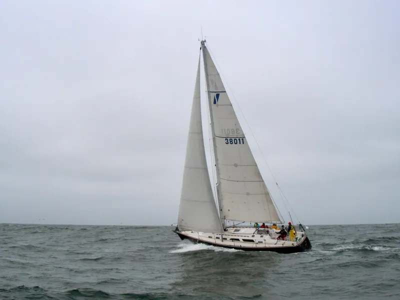 Slide: The Image of Sailing yacht Sabre 402 from 1997 navigating choppy waters under cloudy skies. - 2