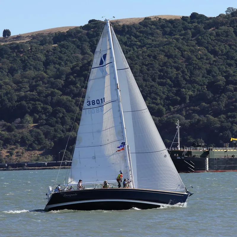 Slide: The Image of Sailing yacht Sabre 402 from 1997 on a scenic waterway with forested hills. - 5