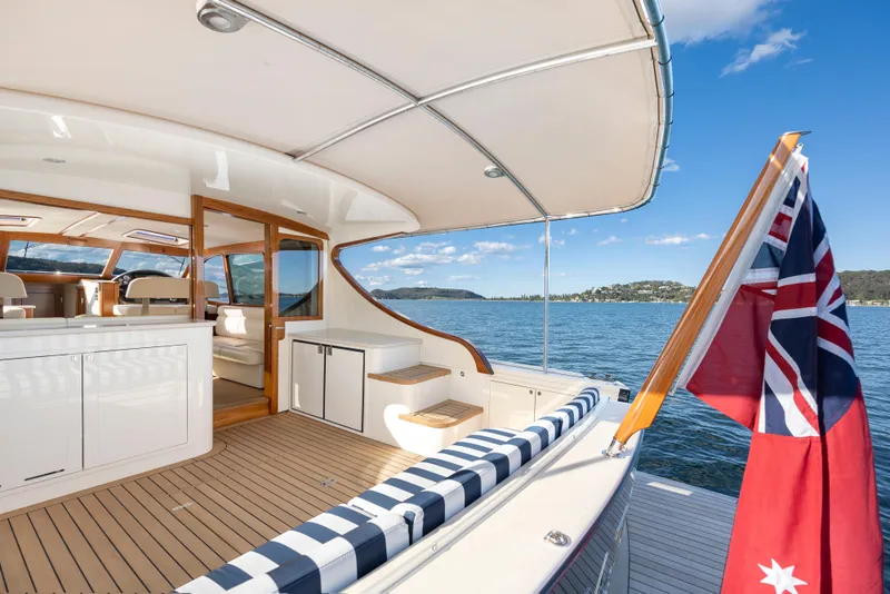 Slide: The Image of 2026 Palm Beach Motor Yachts PB45, elegant deck view with flag, on serene water. - 21