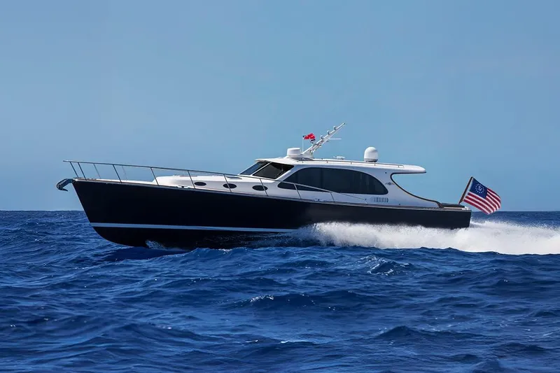 The Image of 2026 Palm Beach Motor Yachts PB45 cruising on open sea with American flag. - 0