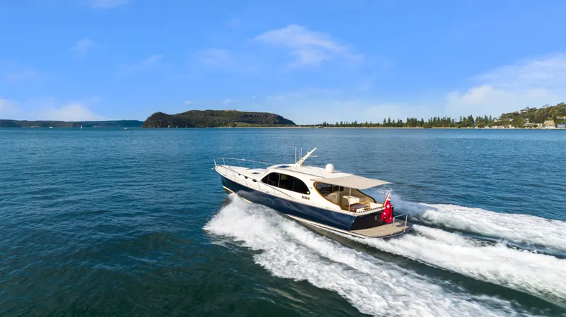Slide: The Image of 2026 Palm Beach Motor Yachts PB45 cruising on open water, scenic coastal backdrop. - 3