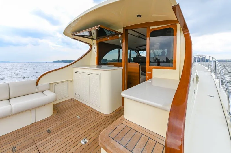 Slide: The Image of 2026 Palm Beach Motor Yachts PB50 deck with elegant wood finish and seating. - 10