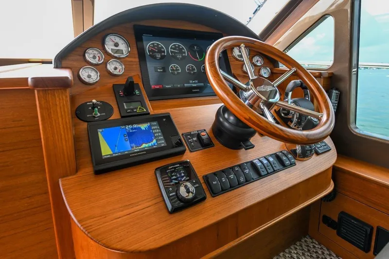 Slide: The Image of 2026 Palm Beach Motor Yachts PB50 helm with wooden steering wheel and navigation instruments. - 15