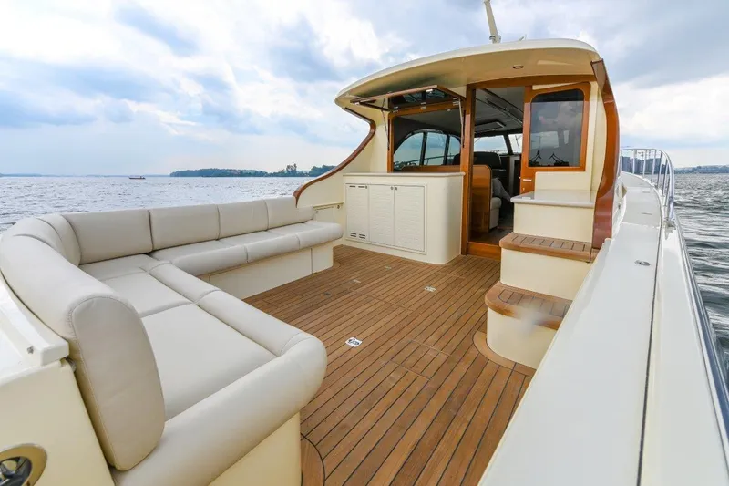 Slide: The Image of 2026 Palm Beach Motor Yachts PB50, luxurious deck with seating, overlooking serene waters. - 11