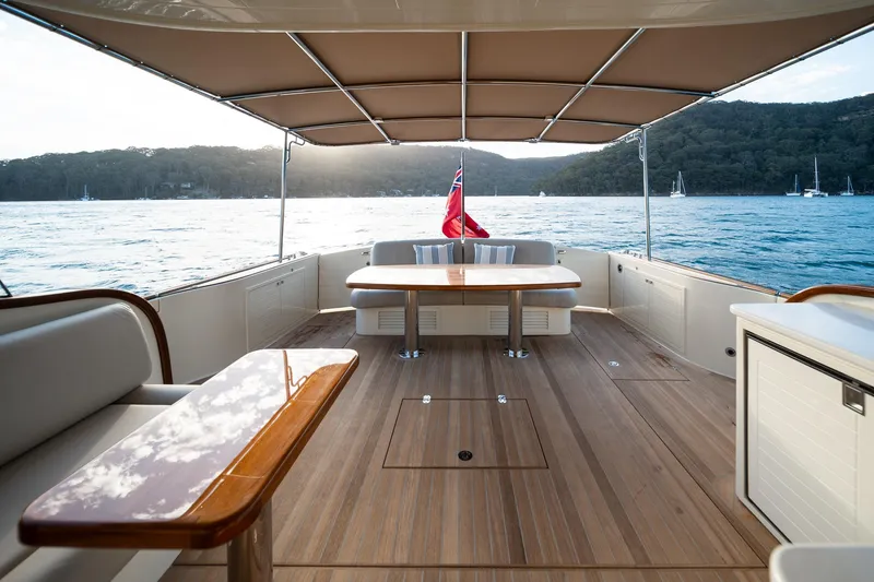 Slide: The Image of 2026 Palm Beach Motor Yachts PB70 deck with elegant wood finish and scenic ocean view. - 23