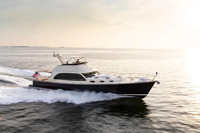 Slide: The Image of 2026 Palm Beach Motor Yachts PB70 cruising on open water at sunset. - 6