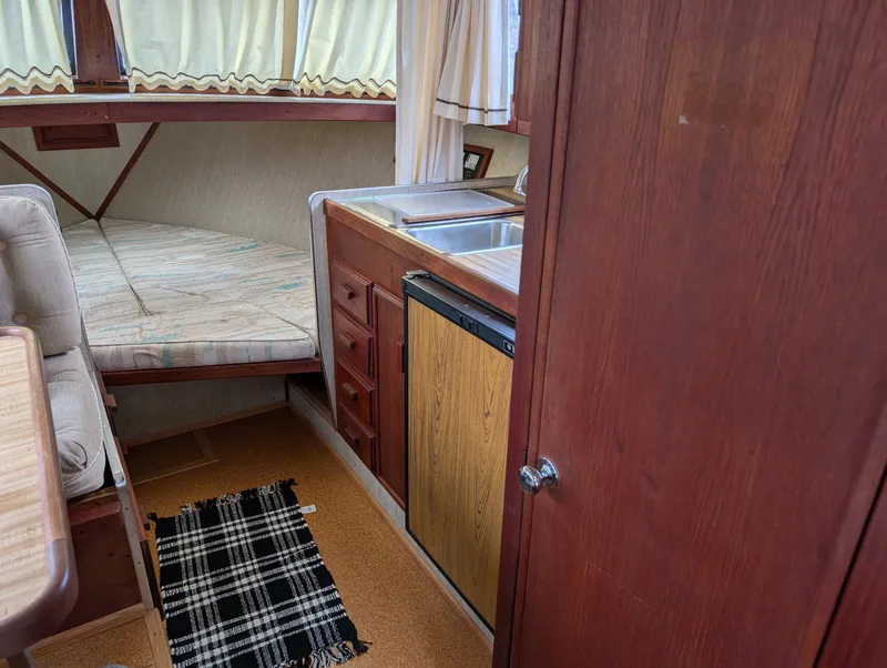 Slide: The Image of 1989 Marinette 28 Sport Fish Fly Bridge interior with kitchenette and sleeping area. - 12