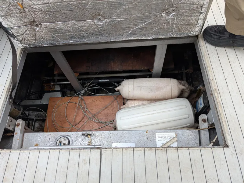 Slide: The Image of Open hatch of 1989 Marinette 28 Sport Fish Fly Bridge showing interior components and wiring. - 16