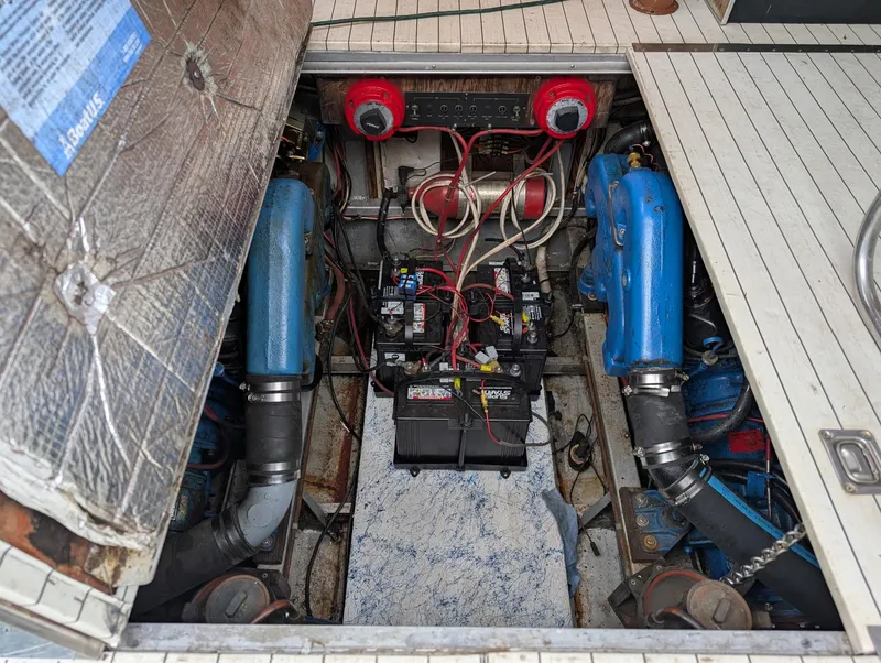 Slide: The Image of Engine compartment of 1989 Marinette 28 Sport Fish Fly Bridge boat, showing dual engines and battery. - 17