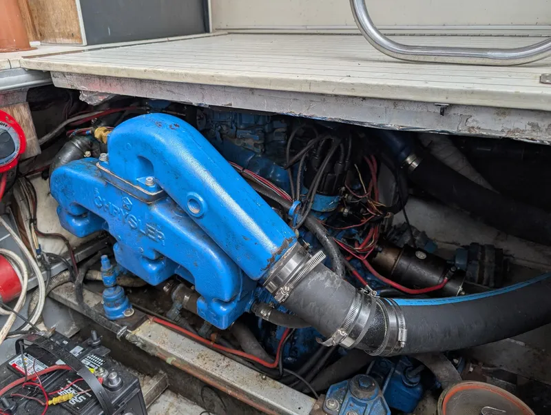 Slide: The Image of Engine compartment of 1989 Marinette 28 Sport Fish Fly Bridge boat, featuring blue engine components. - 23