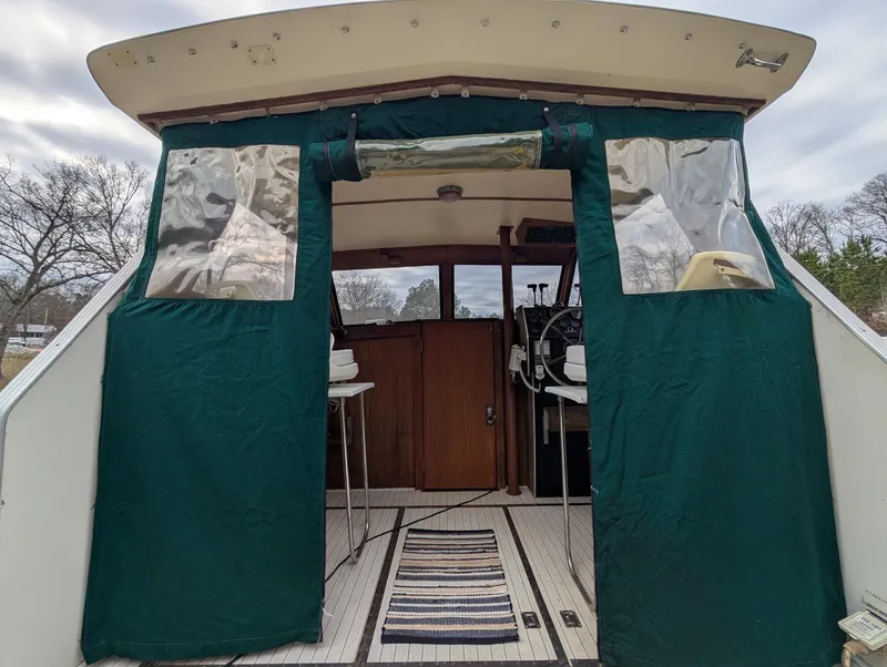 Slide: The Image of 1989 Marinette 28 Sport Fish Fly Bridge with green canvas enclosure and striped rug. - 3