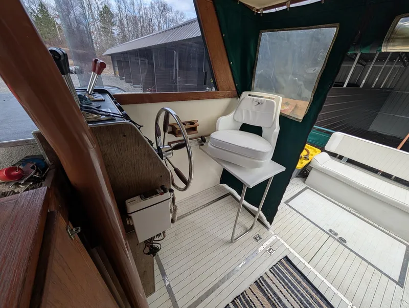 Slide: The Image of 1989 Marinette 28 Sport Fish Fly Bridge interior with steering wheel and seating. - 6