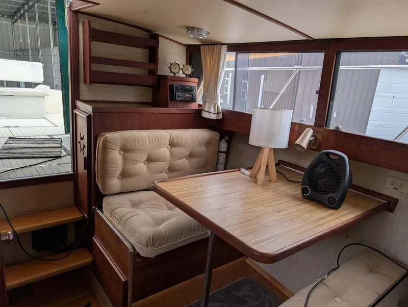 Slide: The Image of 1989 Marinette 28 Sport Fish Fly Bridge interior with cozy seating and wooden table. - 9