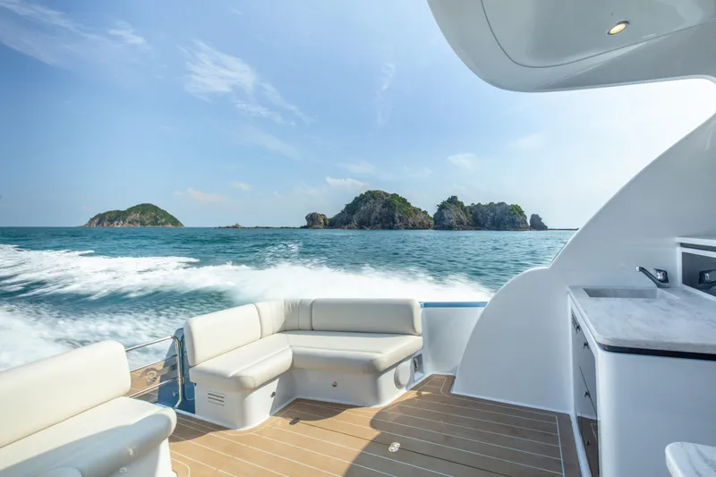Slide: The Image of 2026 Palm Beach Motor Yachts GT50 cruising with island view, featuring luxurious deck seating. - 7
